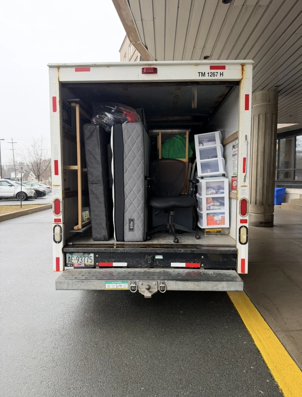 Mattresses, an office chair and storage bins loaded in a Middle Man Movers truck outside a Halifax apartment building.